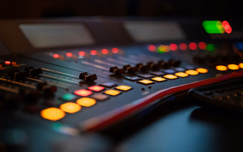 Illuminated audio console controls representing digital tape plugin processing quality