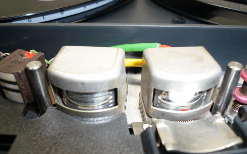 Close-up of reel-to-reel tape heads showing the tape path that creates head bump behavior