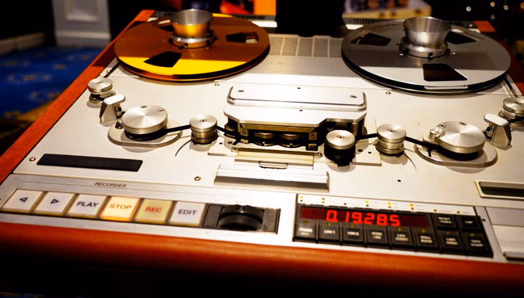 A vintage reel-to-reel tape recorder with transport controls and metering