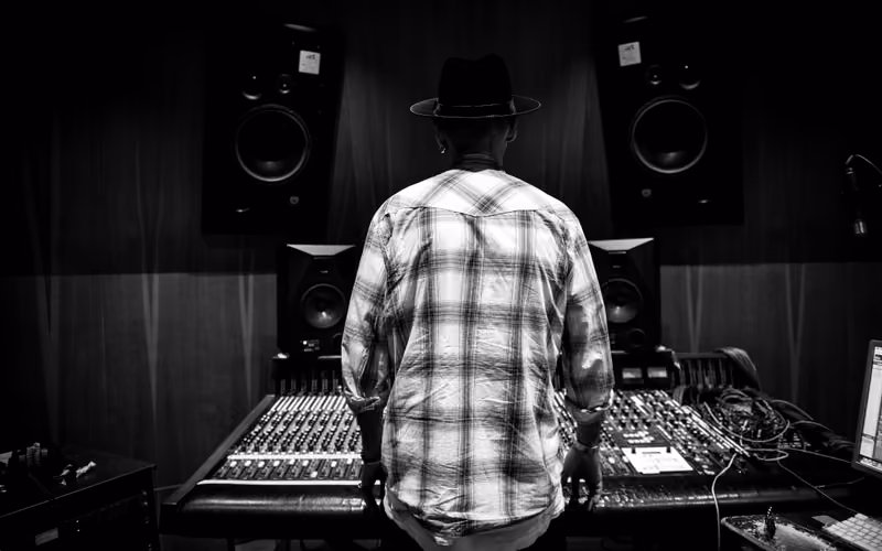 Engineer at a studio mixing desk for professional mastering workflow